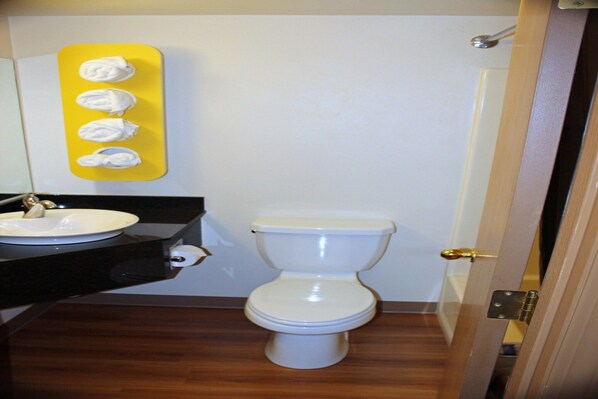 Une salle de bain équipée de toilettes, d’un lavabo et d’un distributeur de mouchoirs jaune.