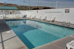 A swimming pool with lounge chairs and a lifeguard station.
