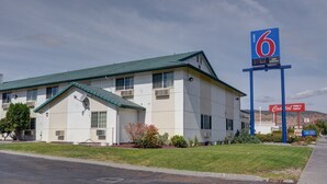A motel with a large sign indicating it is number 6. - 1 QUEEN BED | NON-SMOKING (The Dalles)