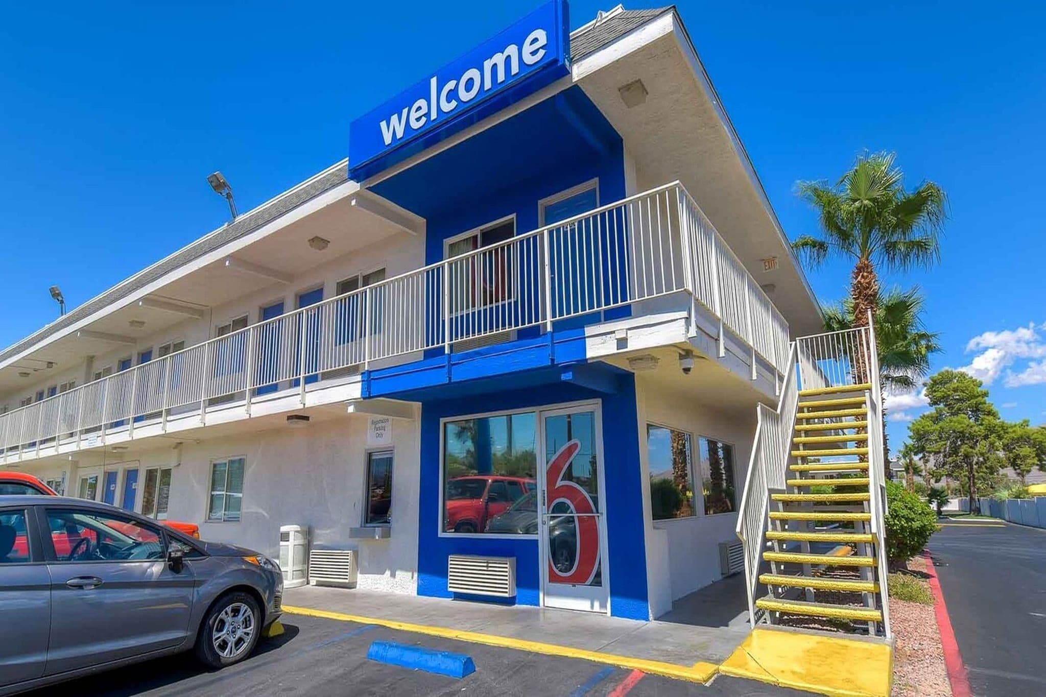 A building with a 'Welcome' sign, a covered entrance, and a visible number '6' on the door.