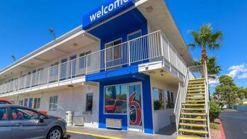 A building with a 'Welcome' sign, a covered entrance, and a visible number '6' on the door.