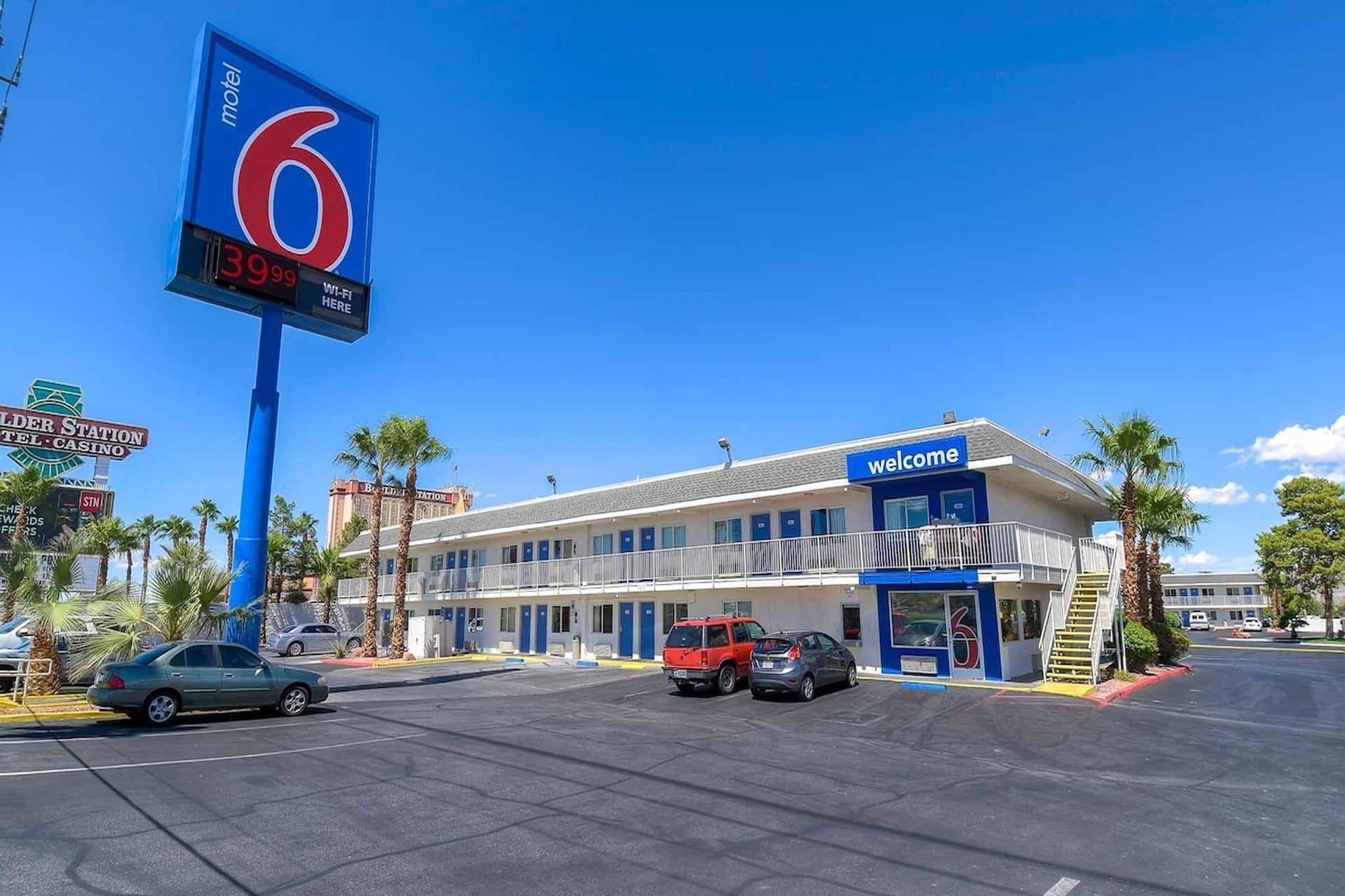 A motel with a large sign displaying the number 6, a 'Welcome' sign, and a digital display showing room rates.