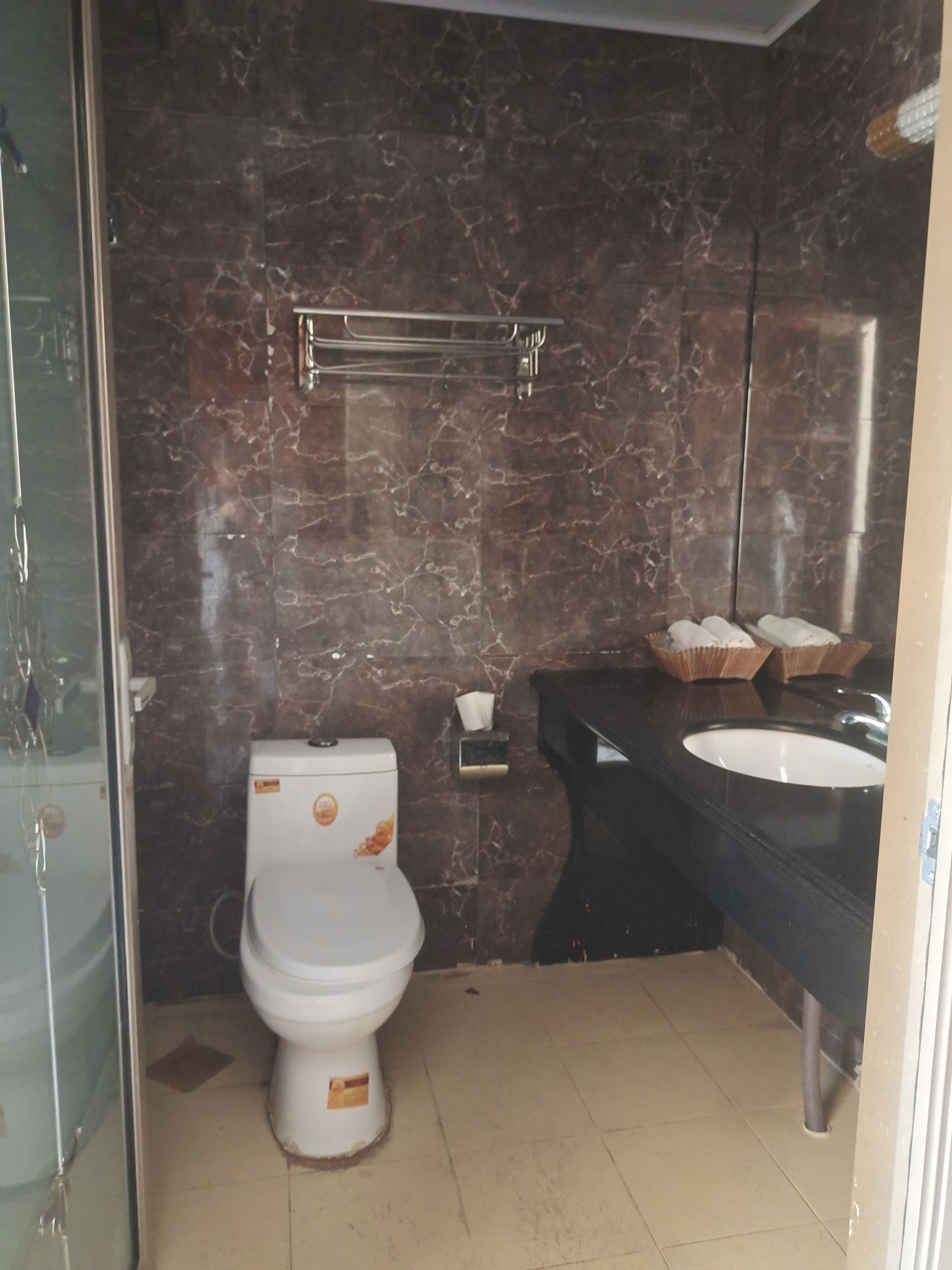 A bathroom with a toilet, a sink, and a towel rack.