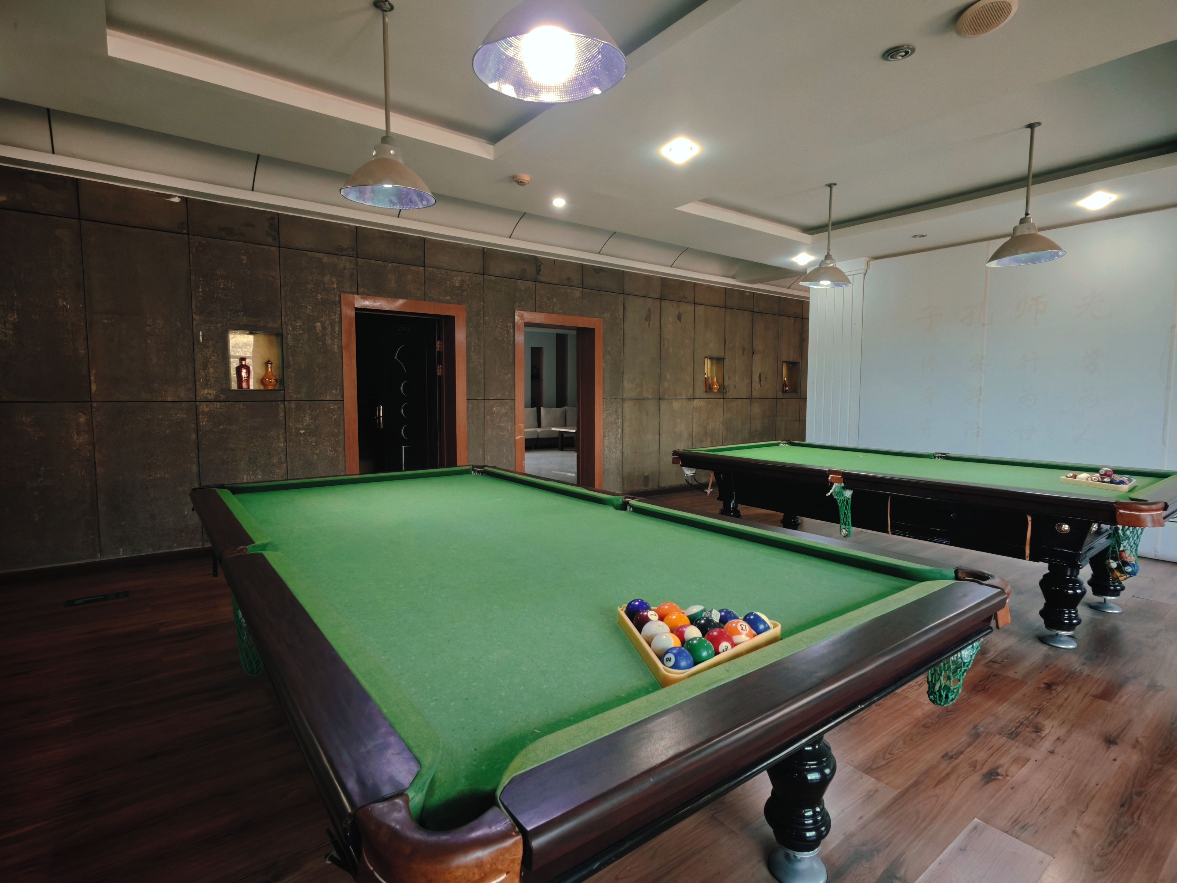 A pool table with a green felt surface and a set of billiard balls.
