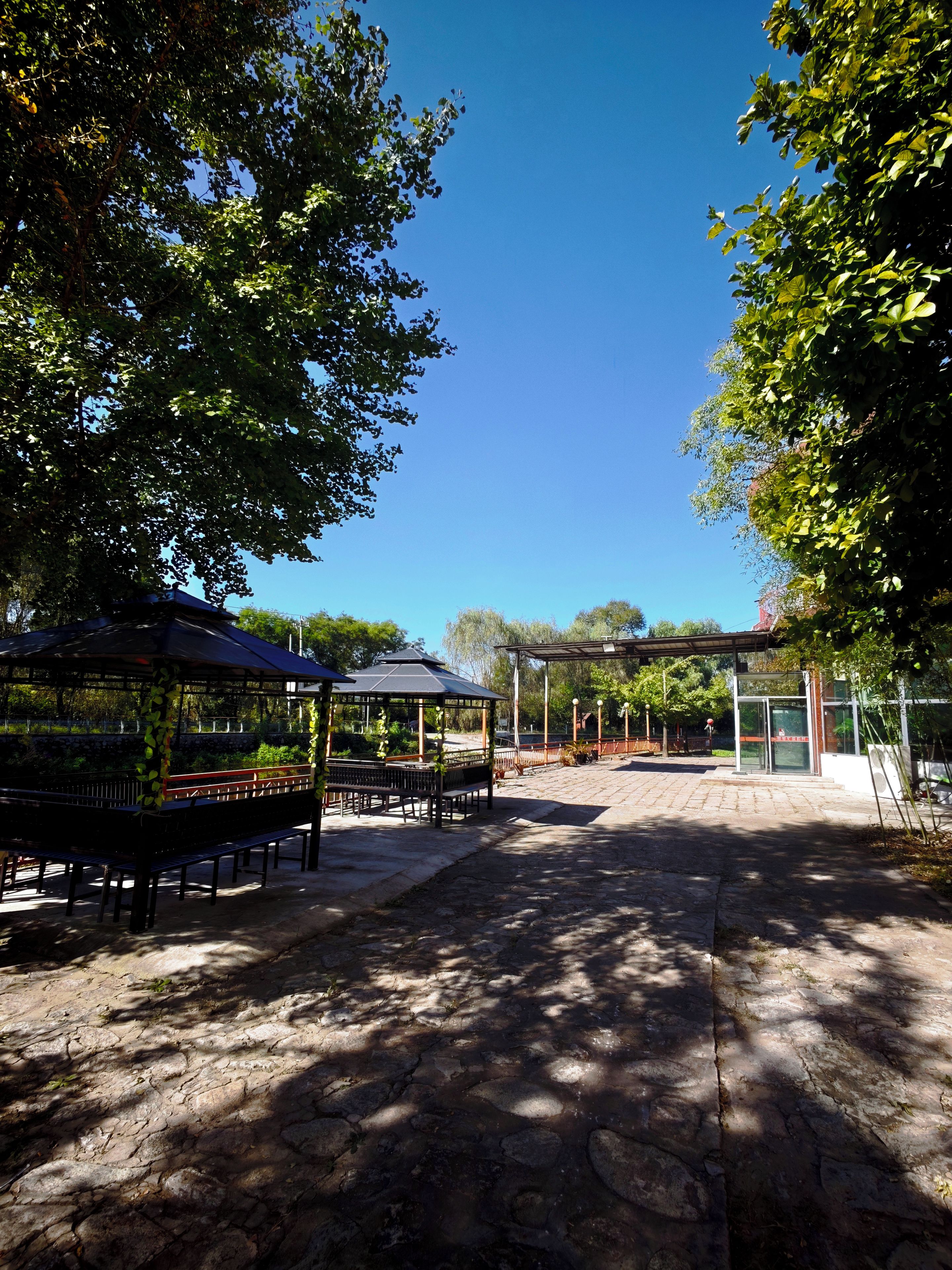 A park with a gazebo, benches, and a covered area.