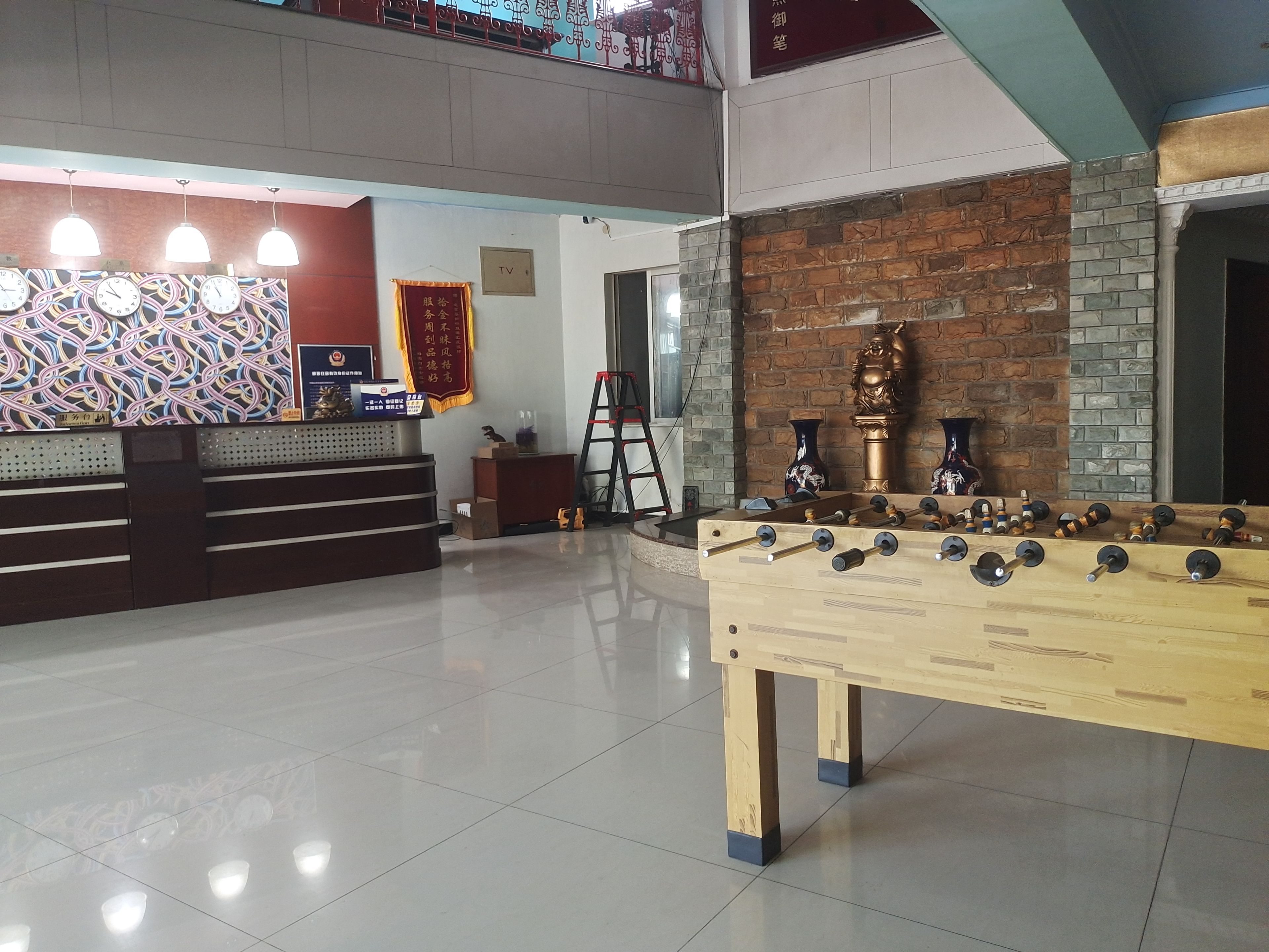 A reception area with a counter, a TV, and a foosball table.