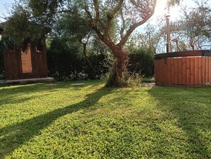 Un patio césped cuidado con una valla de madera y un árbol.