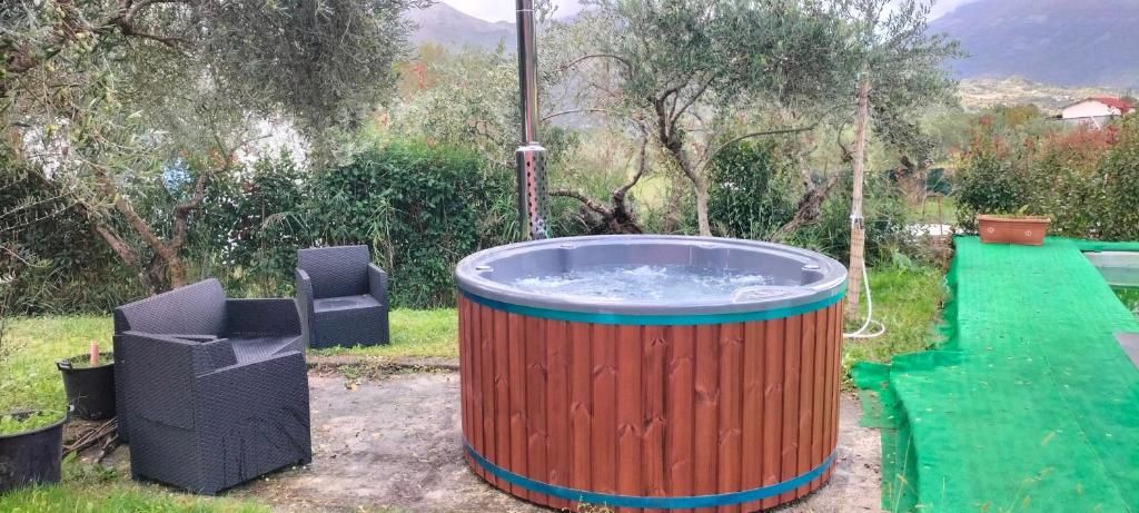 Ein Whirlpool mit Holzverkleidung, umgeben von Pflanzen und Gartenmöbeln.