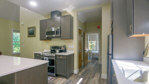 A modern kitchen with stainless steel appliances, wooden cabinets, and a view to the backyard. - Star Valley Retreat in Alpine Near Snake River (Alpine)
