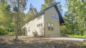 A two-story house with a sloped roof, surrounded by trees and a gravel driveway. - Star Valley Retreat in Alpine Near Snake River (Alpine)