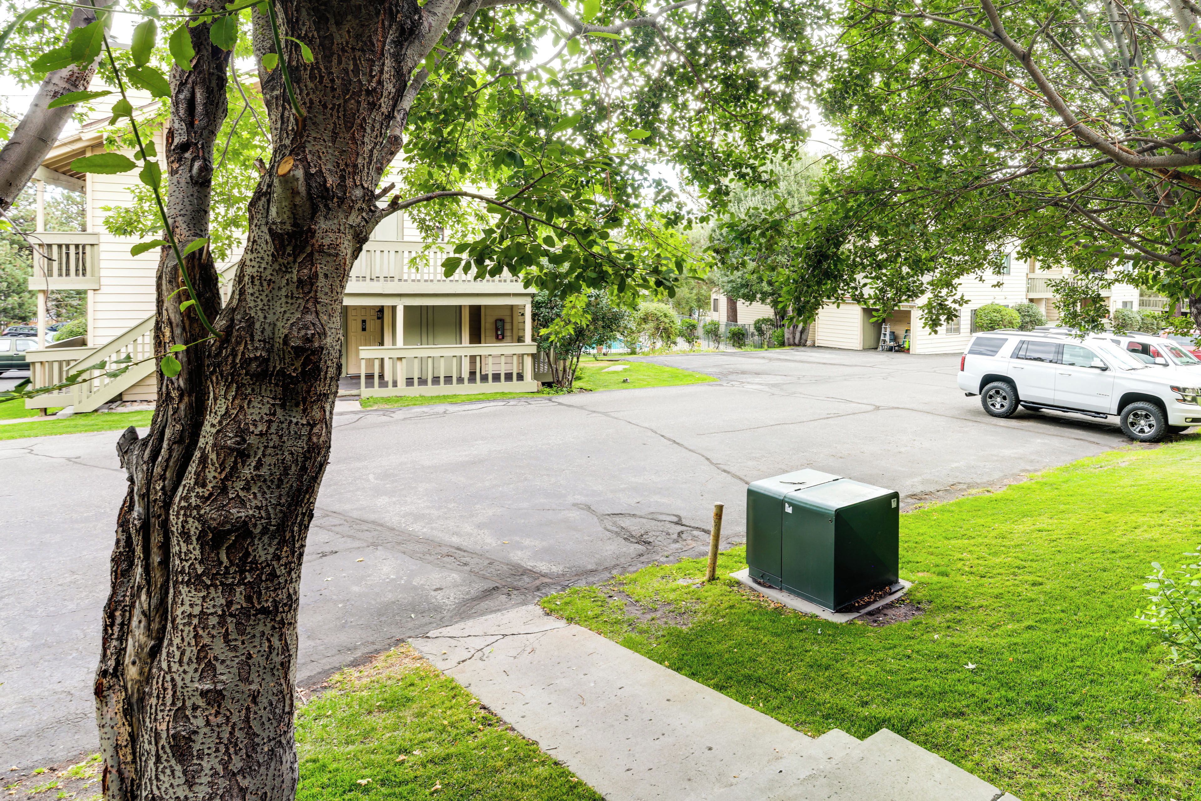 Una calle residencial con casas, un camino de entrada y una camioneta blanca estacionada.