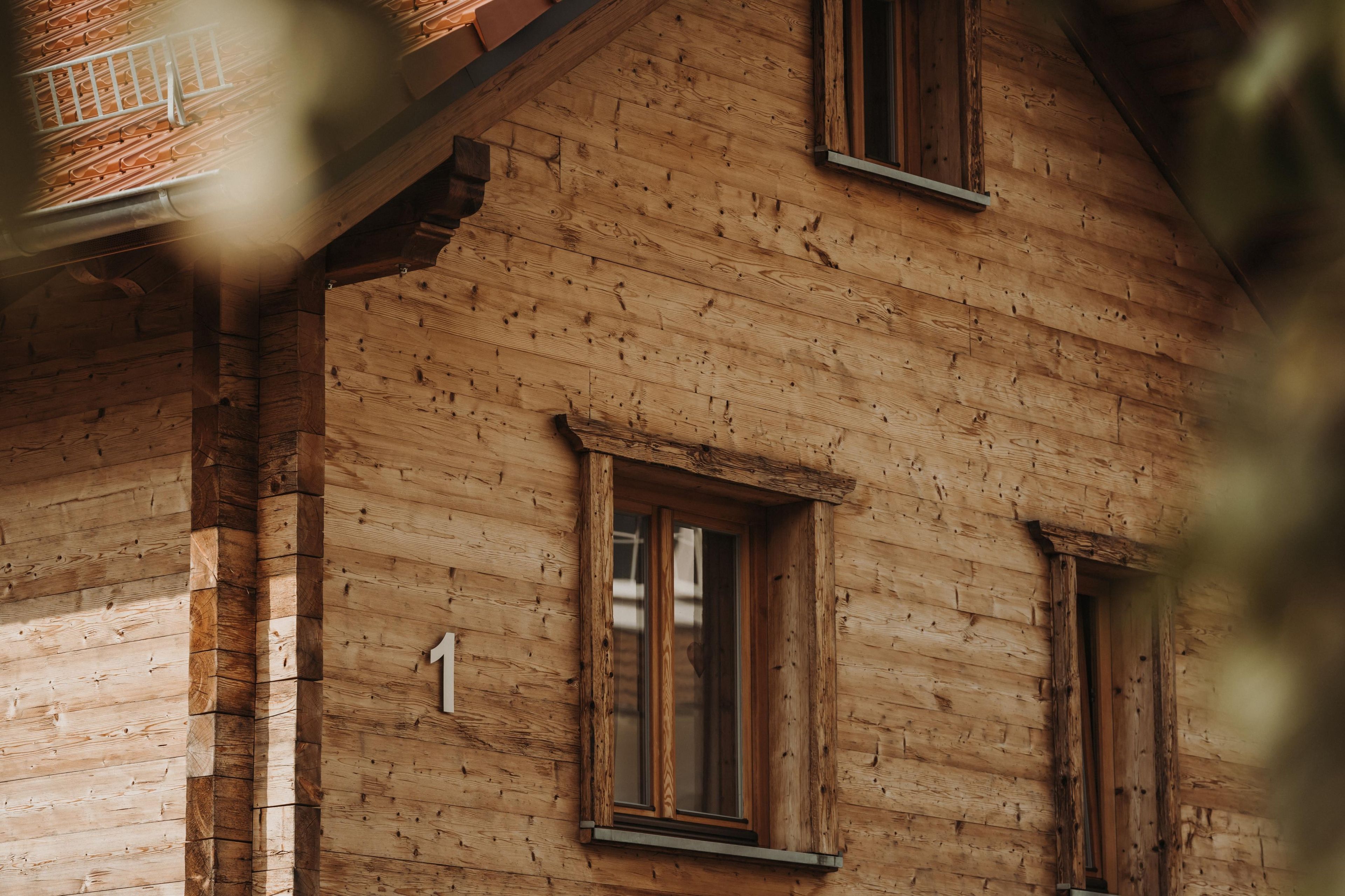 Un bâtiment en bois avec une fenêtre visible et le chiffre « 1 » peint sur le mur.