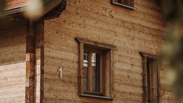 Un bâtiment en bois avec une fenêtre visible et le chiffre « 1 » peint sur le mur.