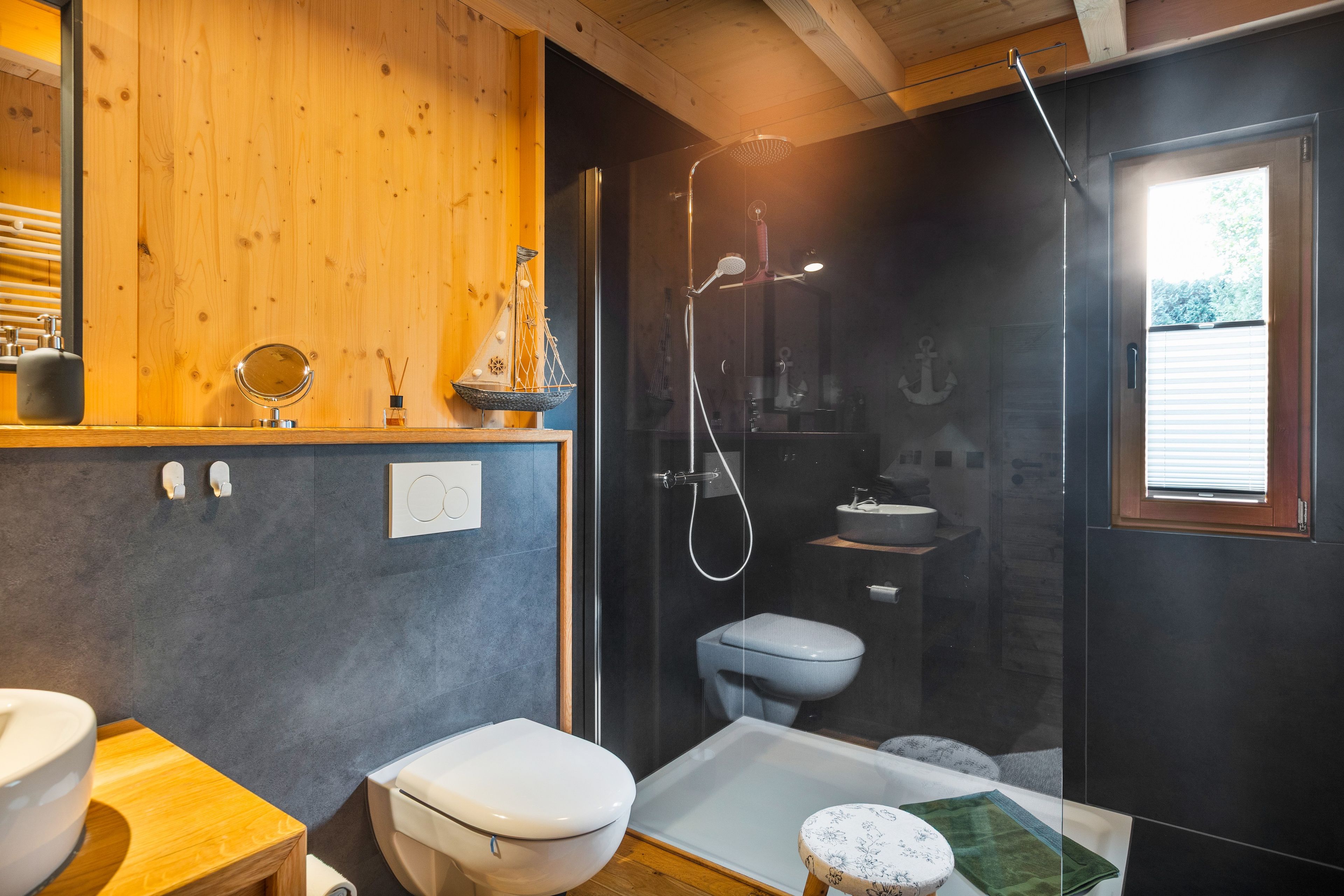 Een moderne badkamer met een houten wastafelmeubel, toilet, bad en douche.