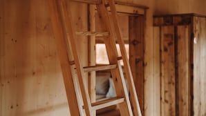 Un interno in legno con una scala di legno appoggiata al muro.