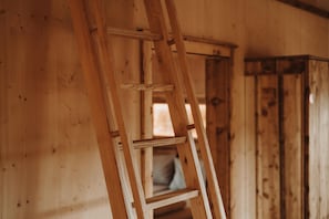 Ein Holzinnenraum mit einer Holzleiter, die an einer Wand anlehnt.