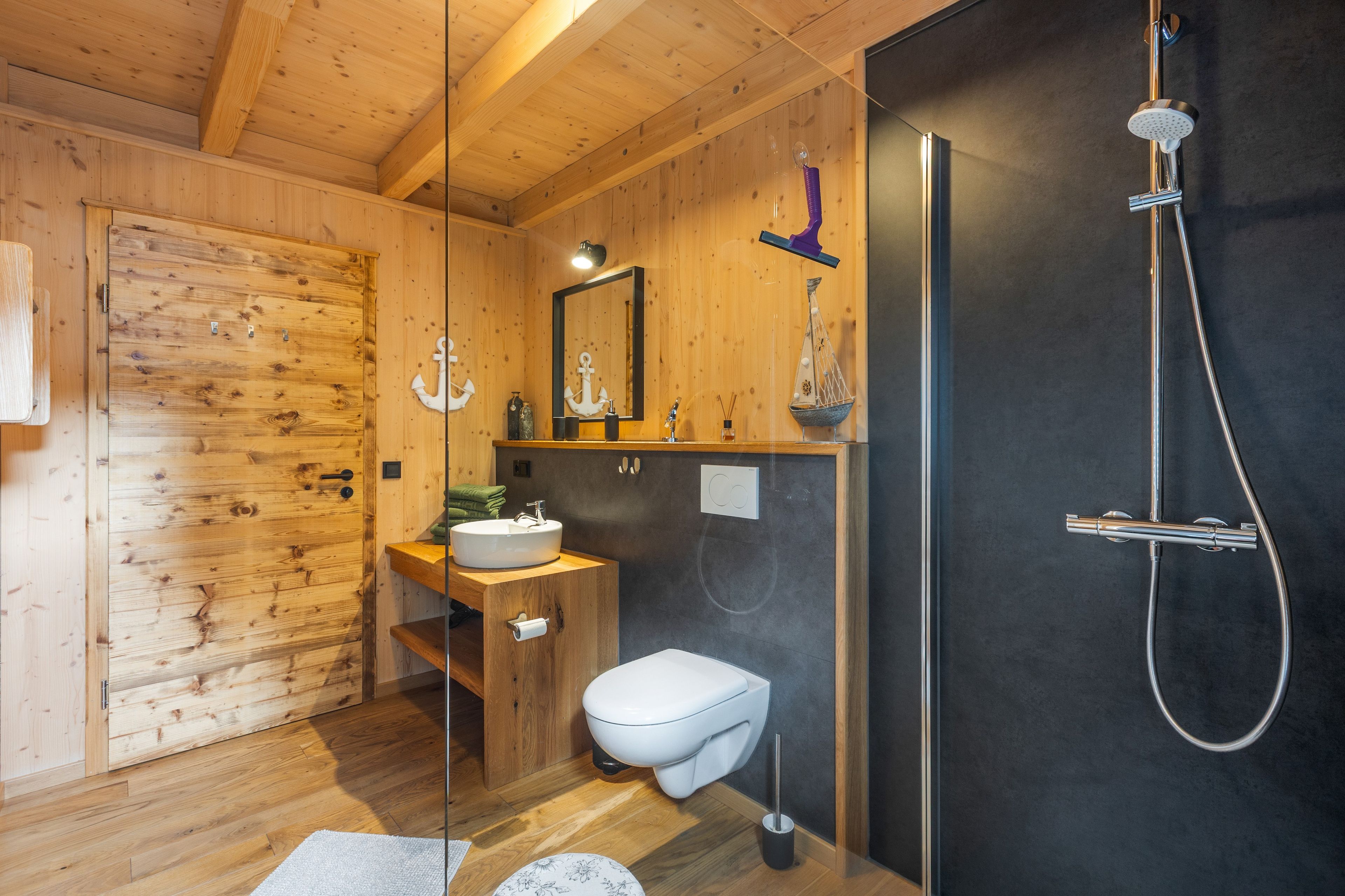 Un baño con detalles de madera, que incluye inodoro, lavabo y ducha.