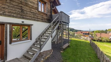 Una casa de madera con una escalera de madera que lleva a una terraza.