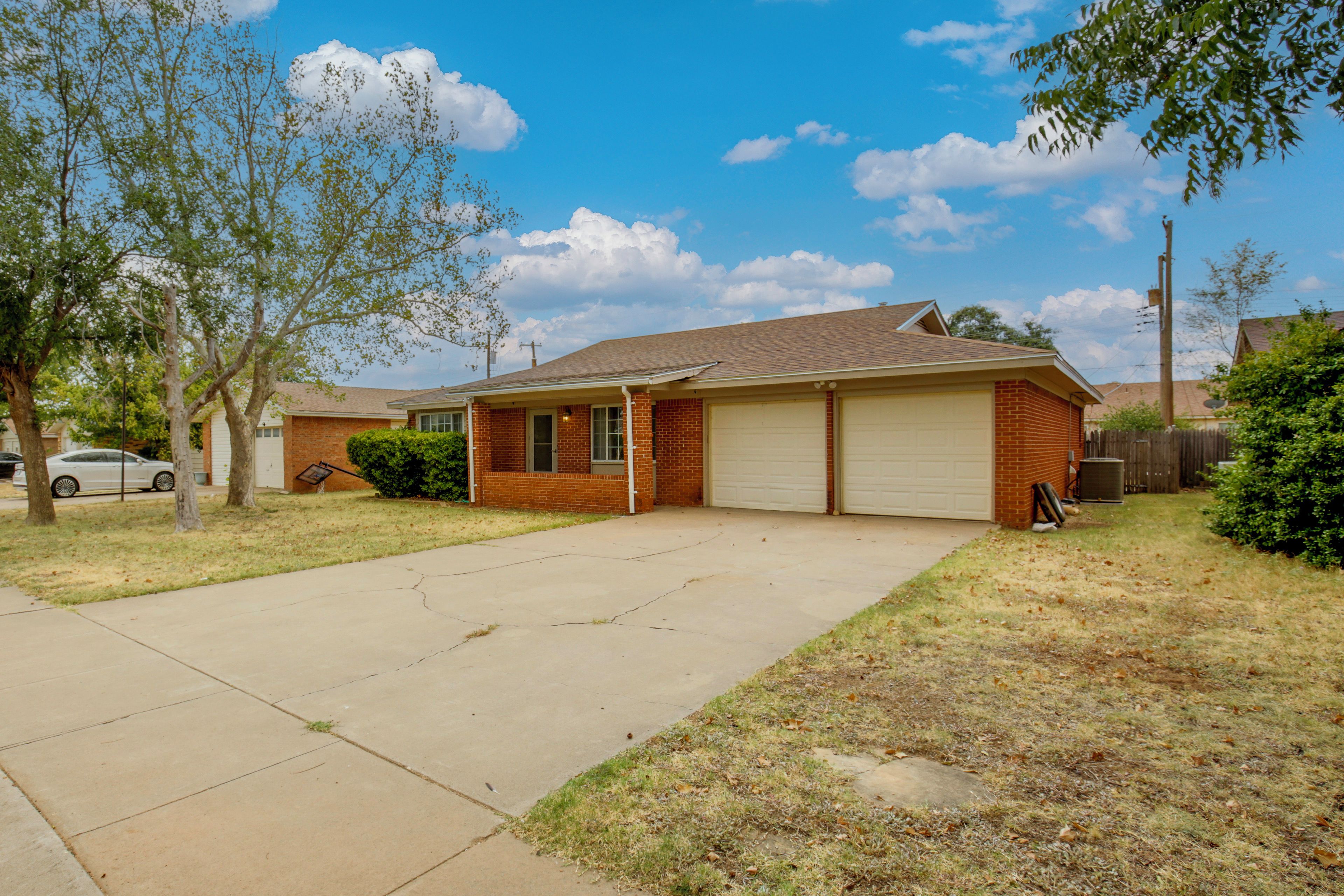 A single-story residential house with a garage, a driveway, and a lawn.