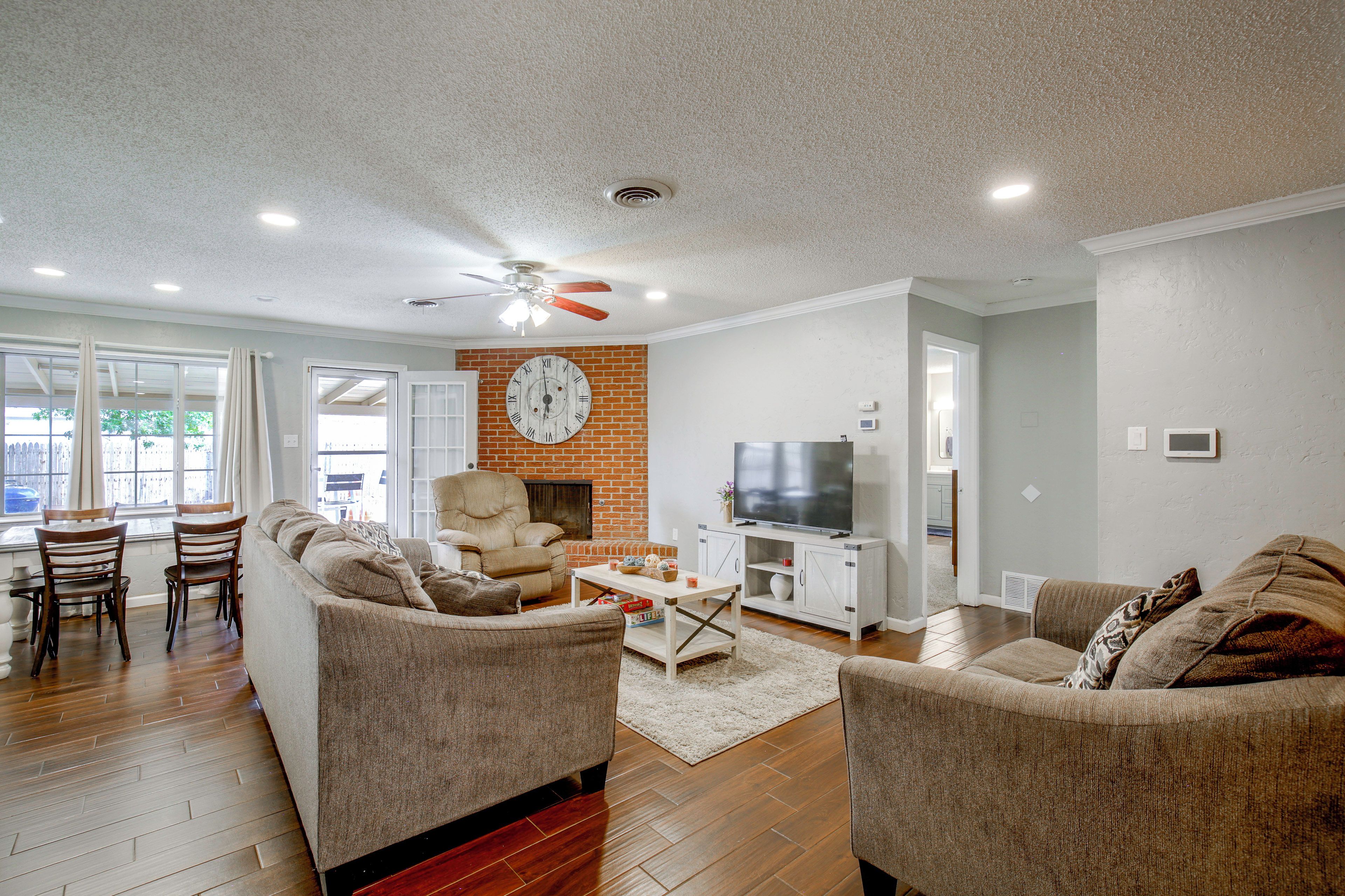 A living room with a fireplace, a television, and a dining area with chairs and a table.