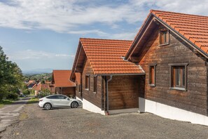 Ein Wohnhaus mit geneigtem Dach, Holzfassade und einem Schotterweg.