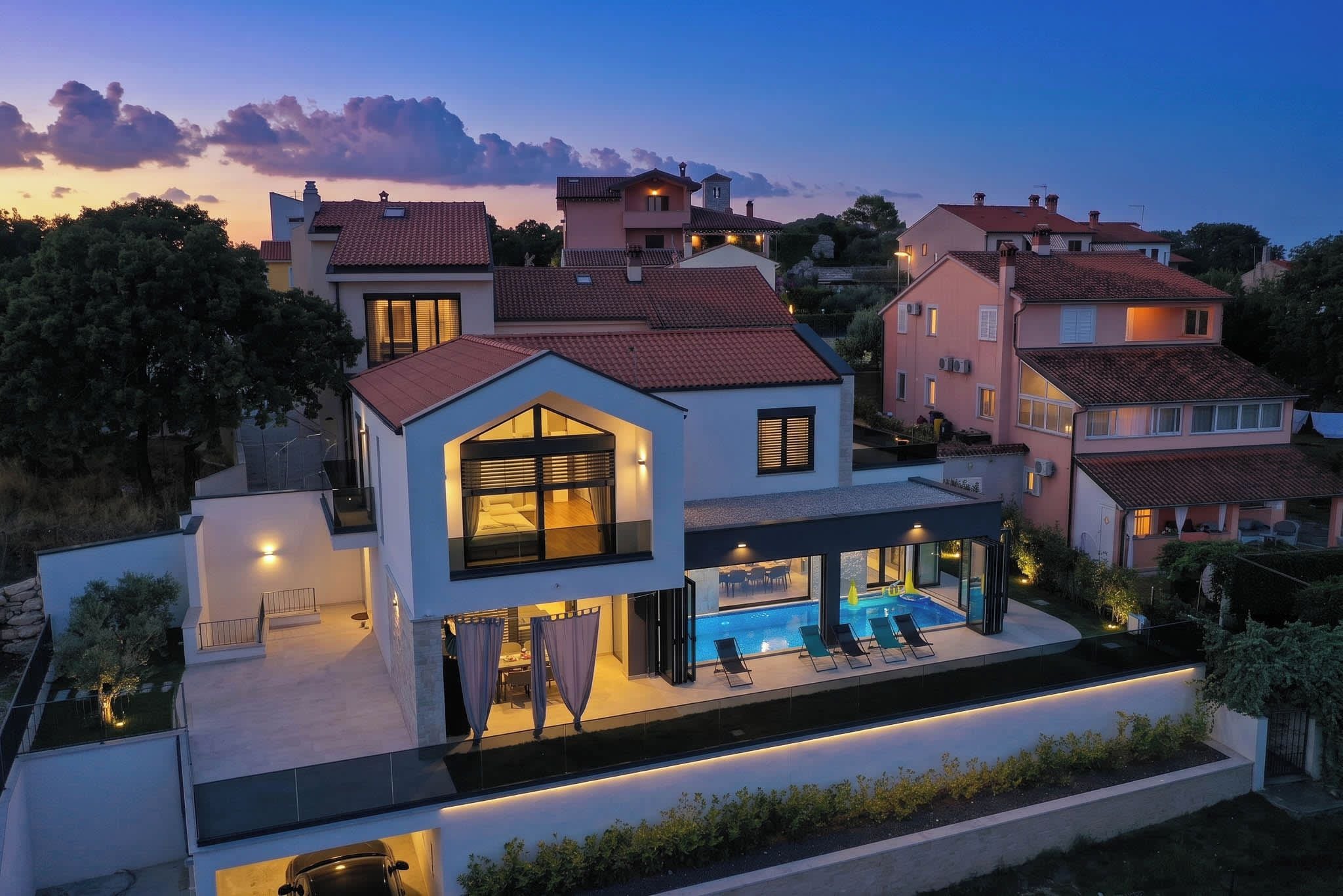 A modern two-story house with a swimming pool, large windows, and a well-lit exterior.