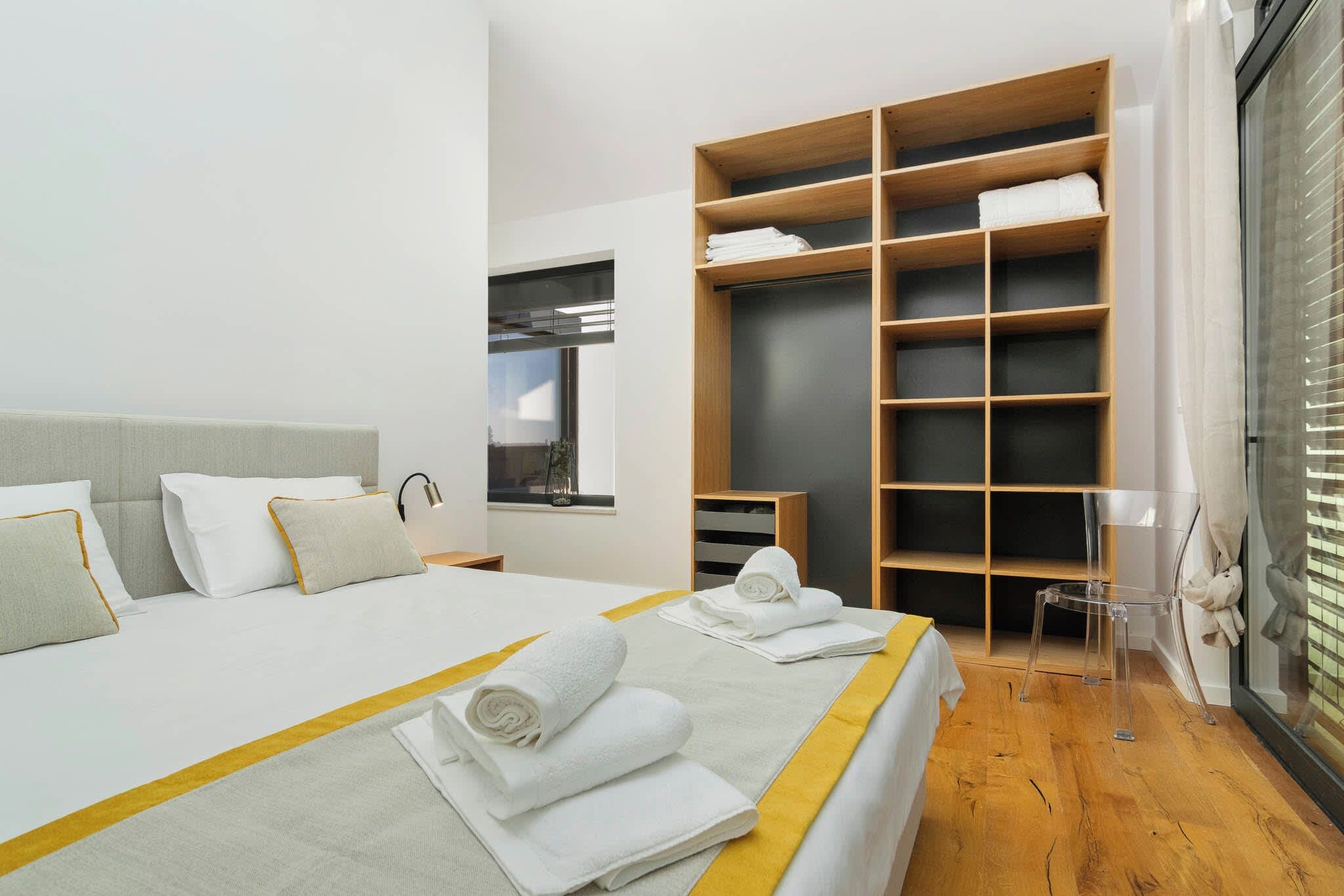 A modern hotel room with a large bed, a wardrobe, and a window.