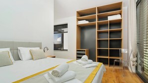 Ein modernes Hotelzimmer mit einem großen Bett, einem Kleiderschrank und einem Fenster.