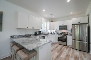 A modern kitchen with white cabinets, stainless steel appliances, and a marble countertop. - Little Rock Family Home, 1 Mi to Dtwn (Little Rock)