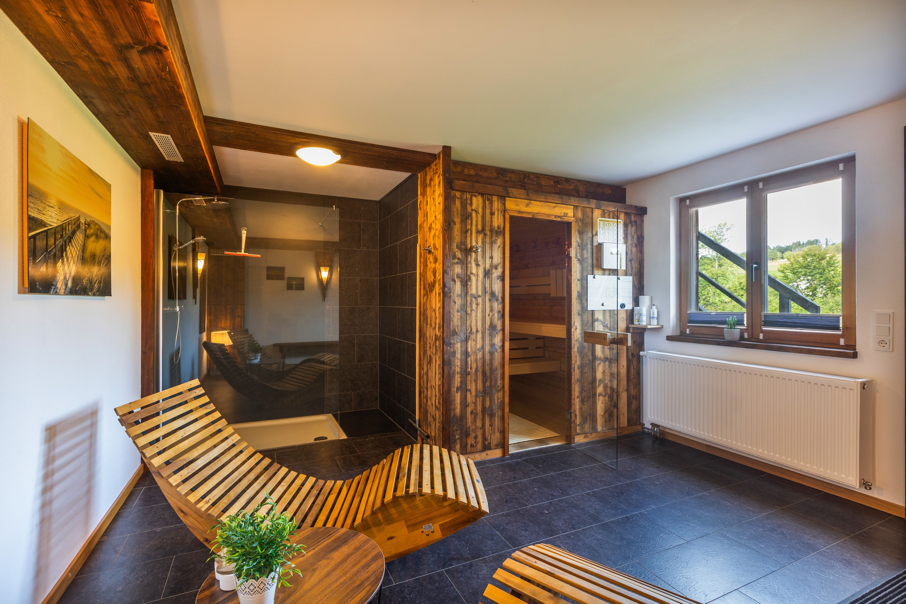Une salle de bain moderne avec une douche à parois de verre, des éléments décoratifs en bois et une vue sur la verdure environnante.
