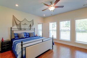 A bedroom with a bed, a ceiling fan, and large windows. - Lake Marion Retreat Dock Days & Backyard Nights (Summerton)