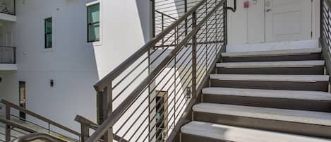 A set of outdoor stairs with metal railings leading to a building entrance.