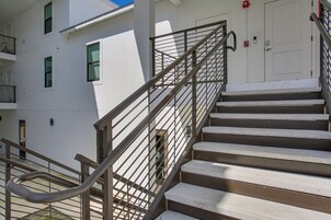 A set of outdoor stairs with metal railings leading to a building entrance.