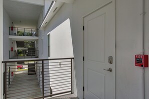 Una puerta blanca con detector de incendios y cerradura electrónica.