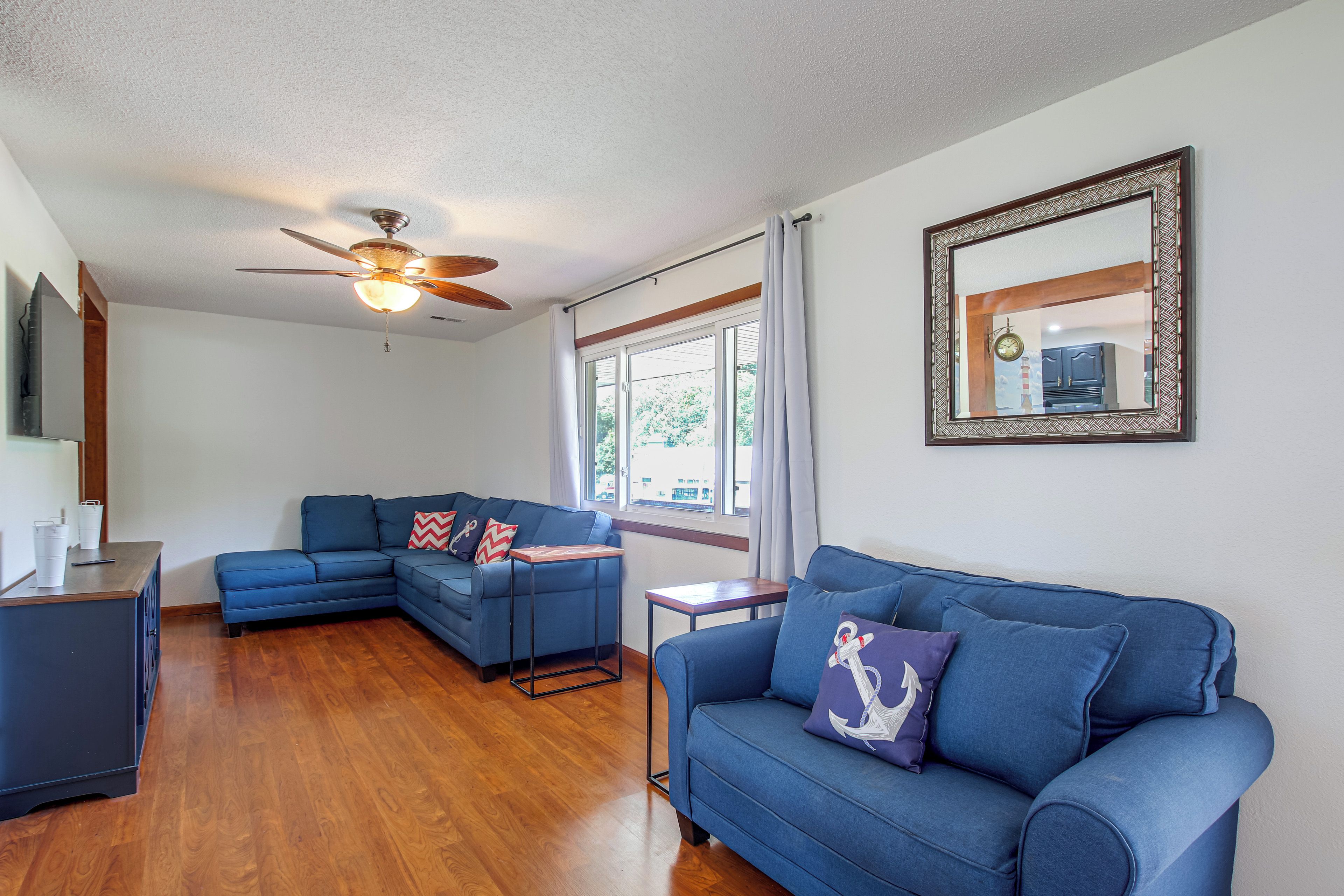 A living room with a sectional sofa, a small table, and a ceiling fan.