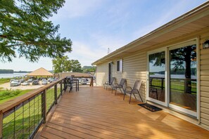 A wooden deck with outdoor furniture, a covered area with a thatched roof, and a view of a body of water. - Spacious Home w/ Deck & Mississippi River Views (Grafton)