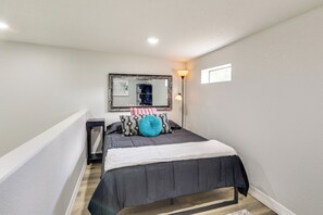 A bedroom with a bed, a bedside table, a mirror, and a nightstand. - Stylish Tiny Home: 6 Mi to Gladewater Antiquing! (Gladewater)