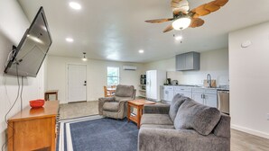 A modern living room with a flat-screen TV, a ceiling fan, and a dining area with a table and chairs. - Orchard, Pond On-site! Farm Stay Near Point A Lake (Red Level)