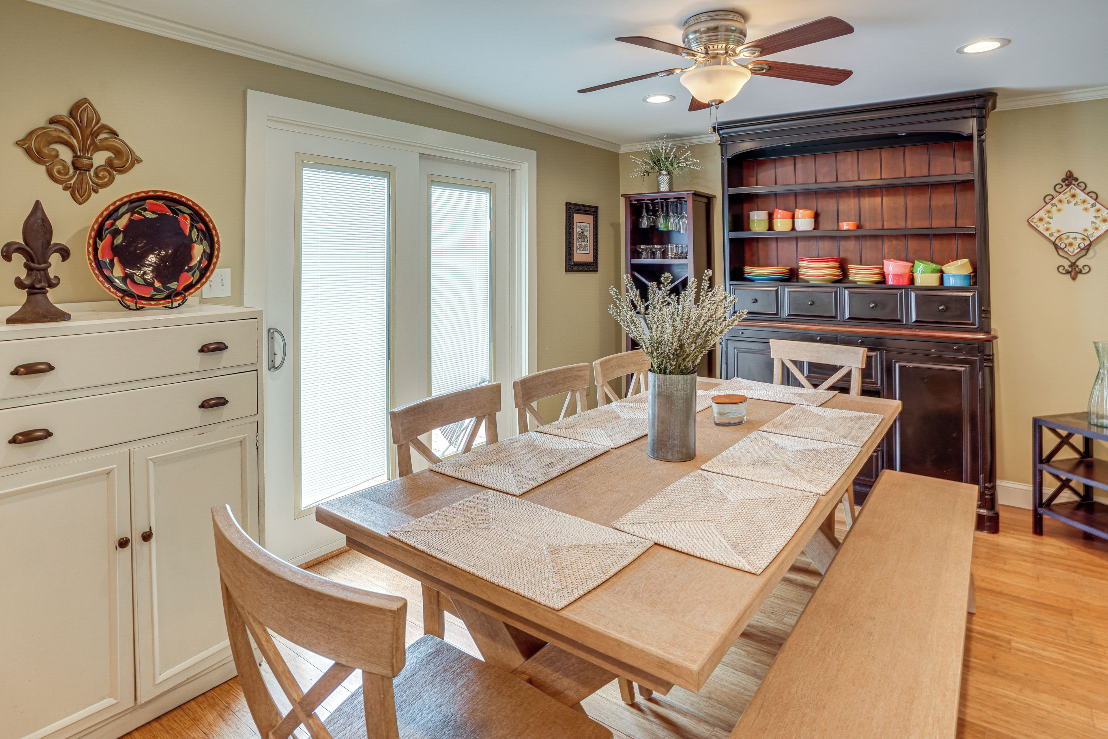 Un coin repas avec une table en bois, des chaises et un ventilateur de plafond.