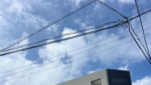 Un edificio moderno de dos pisos con fachada plana, varias ventanas y una entrada visible.