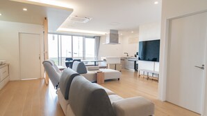 Una sala moderna con sofá, comedor y cocina.