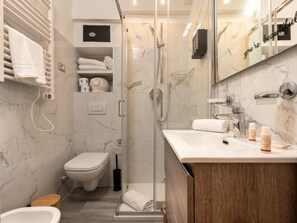 A modern bathroom with a glass-enclosed shower, a toilet, and a vanity with a mirror. - The 6th - Studio Apartment Porta Venezia (Milano)