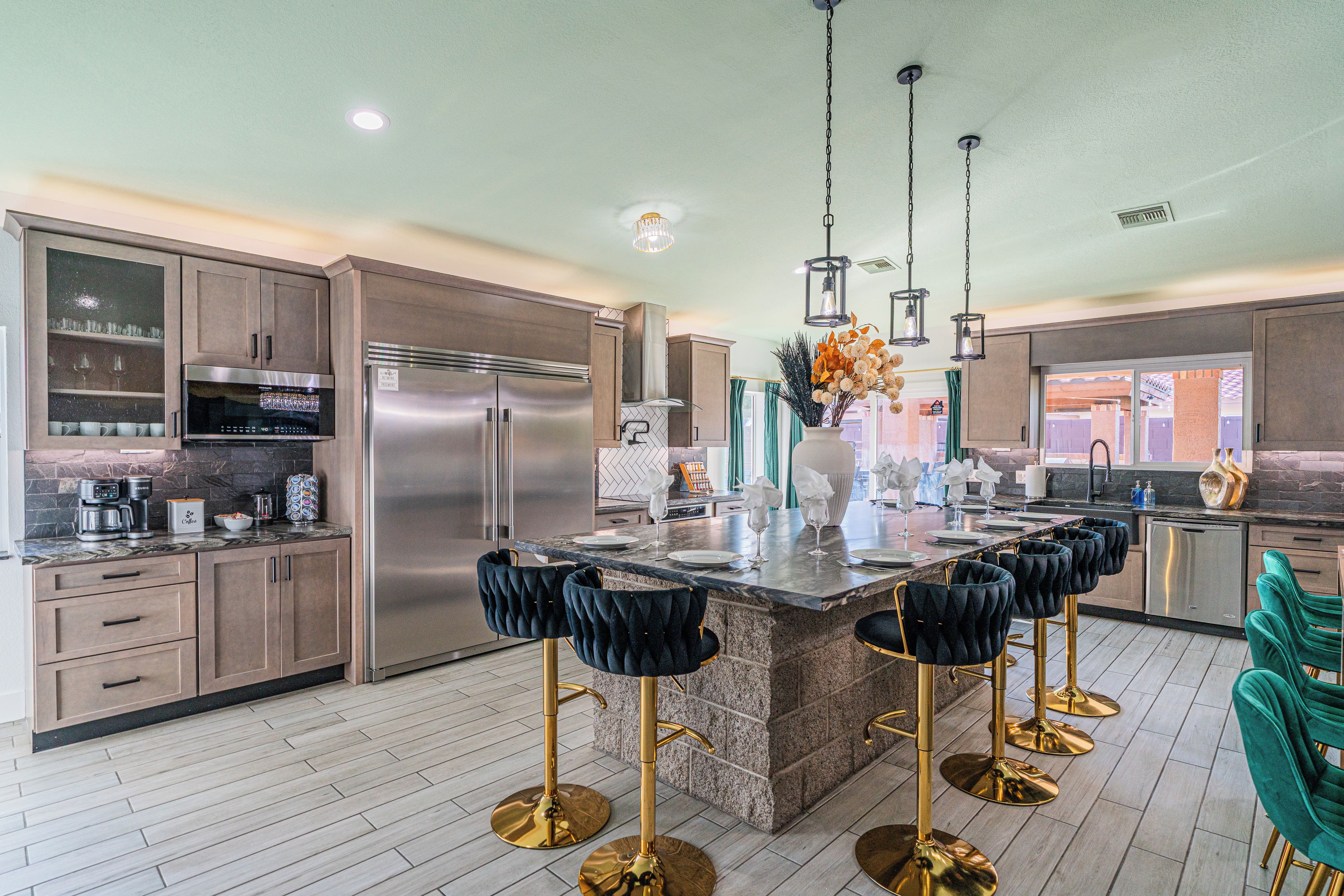 A modern kitchen with a central island, stainless steel appliances, and bar-style seating.