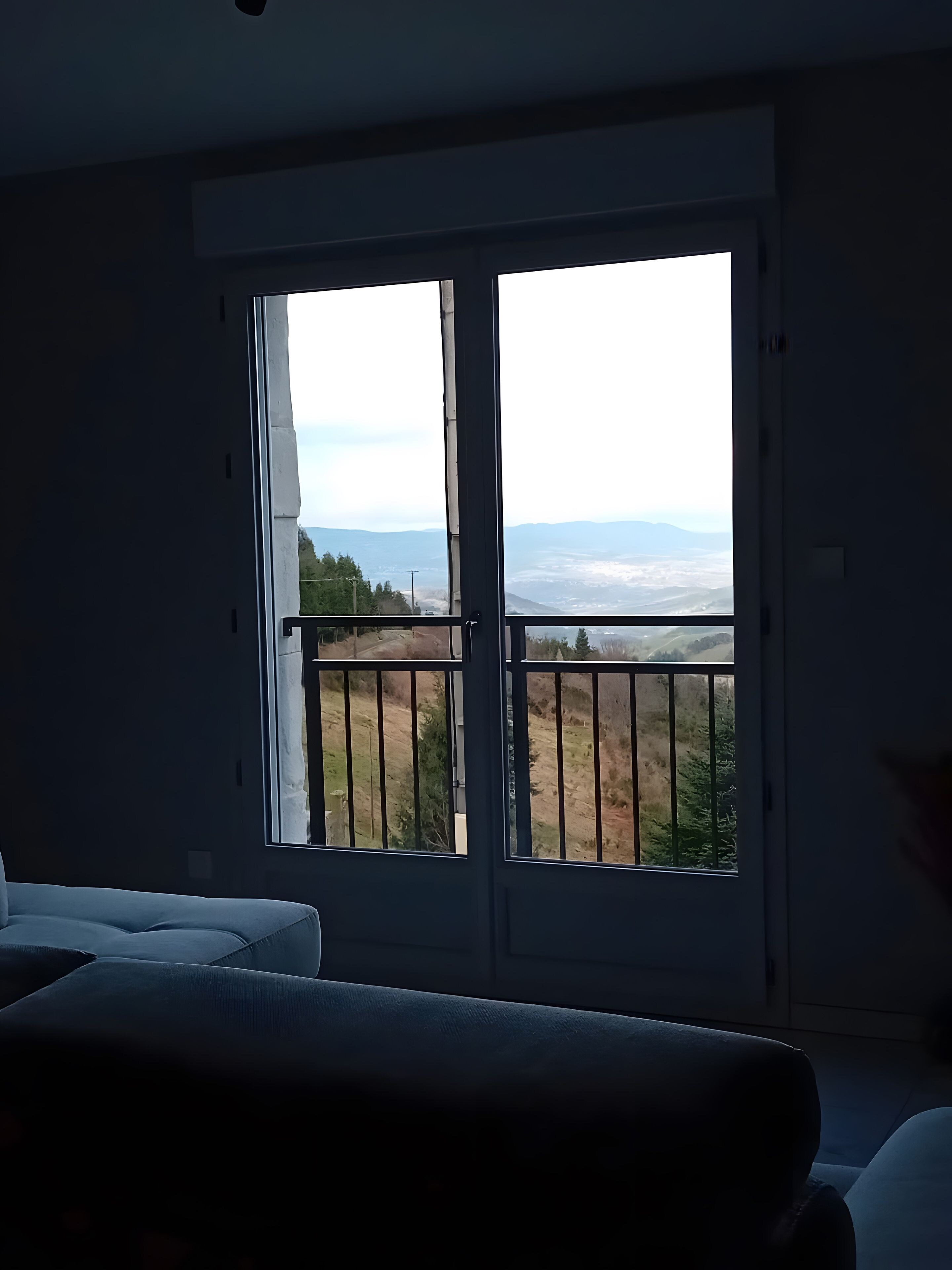 Une pièce dotée d’une grande fenêtre donnant sur un paysage.