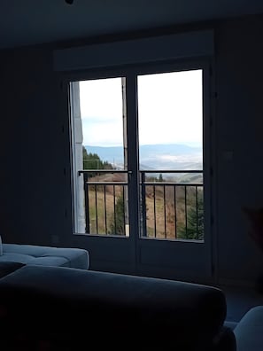 A room with a large window overlooking a landscape.