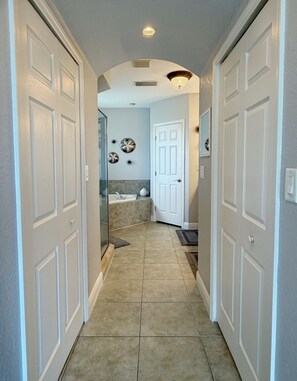 A hallway with a glass shower door, a white door, and a tiled floor. - Mojito Haze- XL Townhome with Rooftop Sunsets, and Redington Beach Views! (Redington Shores)