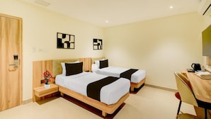 A hotel room with two beds, a desk, and a TV. - Palette Naveena Grand Hyderabad (Hyderabad)