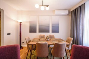 A dining area with a wooden table, six chairs, and a vase of flowers. - Renovated, Stylish, 3BR Kadıköy (Istanbul)