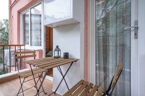 A balcony with wooden furniture, a lantern, and a door with a glass panel. - Renovated, Stylish, 3BR Kadıköy (Istanbul)
