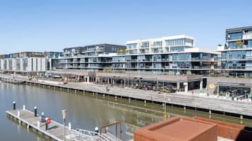A waterfront building with multiple floors, outdoor seating, and a dock.
